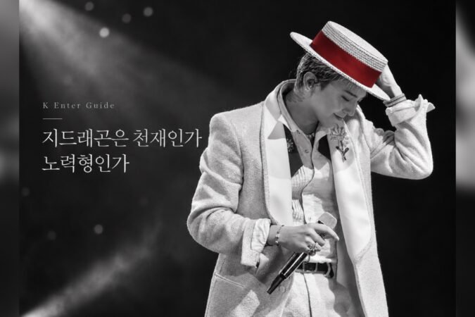 흑백 무대 조명 아래 붉은 띠가 있는 모자를 잡고 고개를 숙인 지드래곤 공연 사진