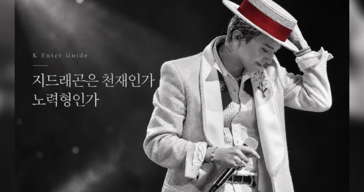 흑백 무대 조명 아래 붉은 띠가 있는 모자를 잡고 고개를 숙인 지드래곤 공연 사진